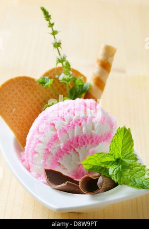 Boule de glace rose blanc crème dans une assiette à dessert Banque D'Images