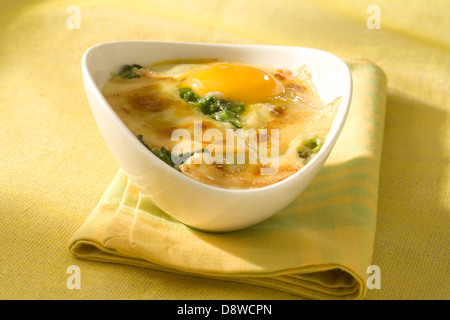 Oeufs cuits aux épinards et fromage à raclette Banque D'Images