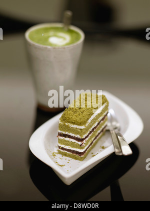 Macha latte et une tranche de gâteau de thé vert Banque D'Images