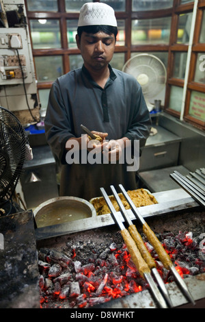 Un homme fait et grilloirs à brochettes Karims Restaurant, Old Delhi Banque D'Images