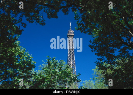 La Tour Eiffel vue à travers la cime des arbres contre le ciel bleu. Banque D'Images