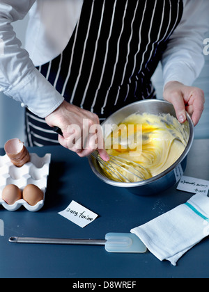 Battre ensemble les œufs, la farine et le sucre avec un fouet Banque D'Images