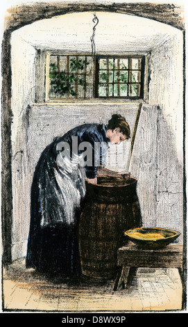 Woman bending over une baratte pour recueillir le beurre. À la main, gravure sur bois Banque D'Images