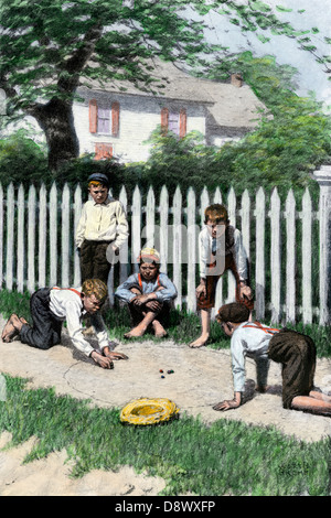 Des garçons jouent à un jeu de billes dans une petite ville, au début des années 1900. À la main, gravure sur bois Banque D'Images