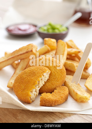 Fishcakes frites petits pois sauce tomate vinaigre de malt à emporter Banque D'Images