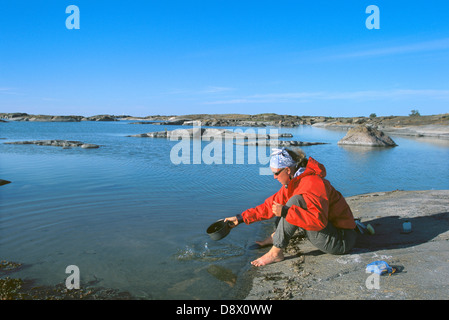 Une femme assise au bord de la mer. Banque D'Images