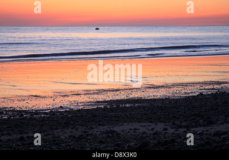 Une vue de l'aube et réflexions colorés sur la plage de Cromer, Norfolk, Angleterre, Royaume-Uni. Banque D'Images