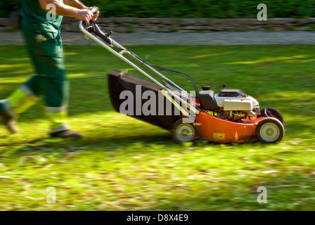 Machine de coupe avec un jardinier de couper le gazon dans un parc Banque D'Images