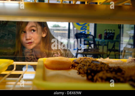 31 mai 2013 - Bartlett, New York, États-Unis - 29 mai 2013 - Lydia Godsey,6, essaie de décider sur lequel donut à choisir à l'aube des beignes sur l'autoroute 70 dans la région de Bartlett. Vendredi, Journée nationale de l'anneau. Les boulangers sera la cuisson toutes les heures de la nuit pour satisfaire la demande de donuts pour leurs clients réguliers. La première journée a été créé par l'anneau de l'Armée du Salut pour aider à recueillir des fonds au cours de la Grande Dépression. (Crédit Image : © Karen Pulfer Focht/l'appel Commercial/ZUMAPRESS.com) Banque D'Images