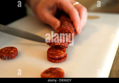 Close up d'un couteau couper des tranches de chorizo espagnol Banque D'Images