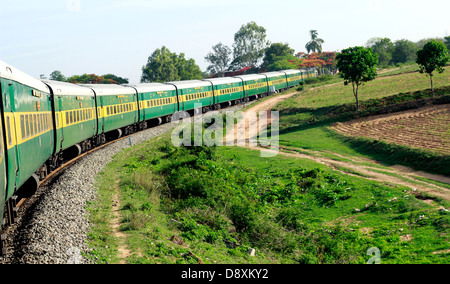 Un train des chemins de fer indiens (Garib rath) une courbe de manoeuvres dans les Ghâts occidentaux, Tamil Nadu, Inde. Banque D'Images