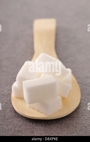 Morceaux de sucre sur une cuillère en bois Banque D'Images