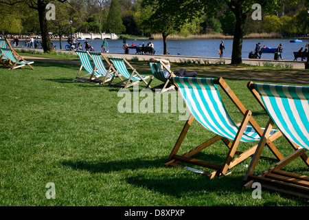 Des chaises longues en face de la Serpentine, à Hyde Park, Londres, UK Banque D'Images