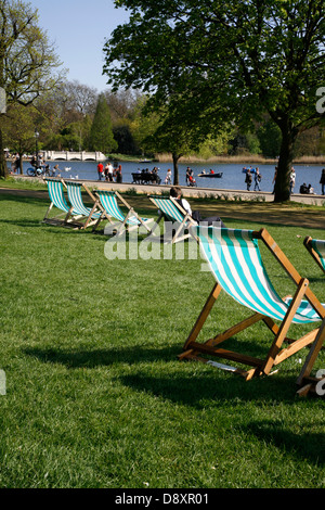 Des chaises longues en face de la Serpentine, à Hyde Park, Londres, UK Banque D'Images