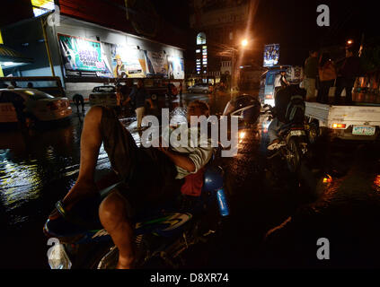 Davao, Philippines. 6e juin 2013. Motorist dormir au dessus de sa moto comme il l'attendre pour le niveau d'eau à descendre après avoir frappé par les inondations en ah repousse rongeur Davao City, Philippines du Sud, 06 juin 2013.Le Philippine des Services atmosphériques, géophysiques et astronomiques de l'Administration (PAG-ASA) a dit qu'une zone de convergence intertropicale (ZCIT) influent sur la partie sud des Philippines qui déclenche les crues hi de l'eau dans la ville. Credit : Eli Ritchie Tongo/Alamy Live News Banque D'Images