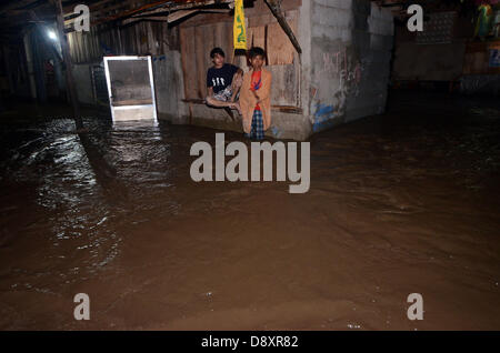 Davao, Philippines. 6e juin 2013. Stand philippins et siège dans leurs fenêtres comme cause de l'eau d'inondation par une forte pluie a frappé des maisons dans la ville de Davao, Philippines du Sud, 06 juin 2013.Le Philippine des Services atmosphériques, géophysiques et astronomiques de l'Administration (PAG-ASA) a dit qu'une zone de convergence intertropicale (ZCIT) influent sur la partie sud des Philippines qui déclenche le niveau d'eau des crues hi dans la ville. Credit : Eli Ritchie Tongo/Alamy Live News Banque D'Images