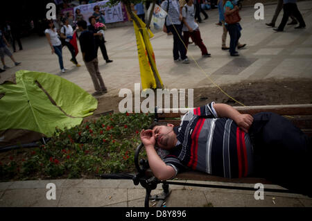 Istanbul, Turquie. 6 juin, 2013. Un homme dort sur un banc de la place Taksim. Après plusieurs jours de conflit, la Place Taksim à Istanbul était calme le 6 juin, avec les gens du camping et de personnes scandant des slogans contre le gouvernement. Crédit : Jordi Boixareu/Alamy Live News Banque D'Images