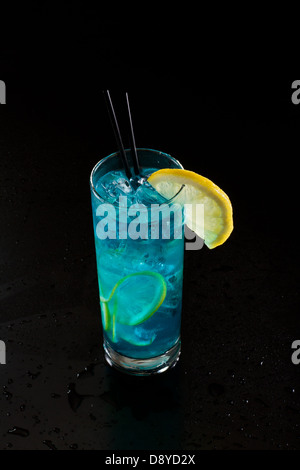 Limonade bleu vif servi dans un grand verre isolé sur un fond noir Banque D'Images