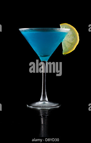 Limonade bleu vif servi dans un martini isolé sur un fond noir Banque D'Images