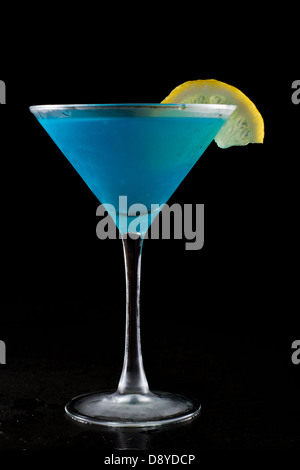 Limonade bleu vif servi dans un martini isolé sur un fond noir Banque D'Images