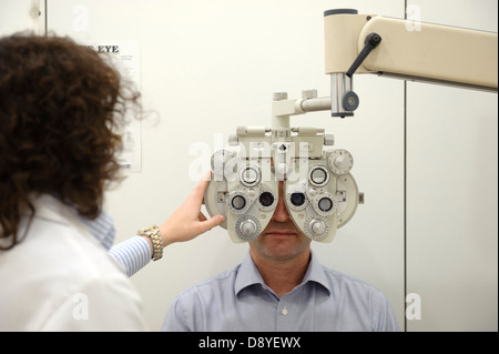 Portrait d'un homme ayant les yeux testés avec un phoropter Banque D'Images