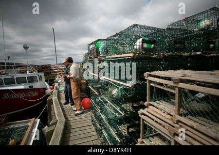 Casiers à homard s'asseoir sur un petit quai qui héberge quelques bateaux de pêche du homard dans la région le long du Cap Breton, Nouvelle-Écosse Cabot Trail. Banque D'Images