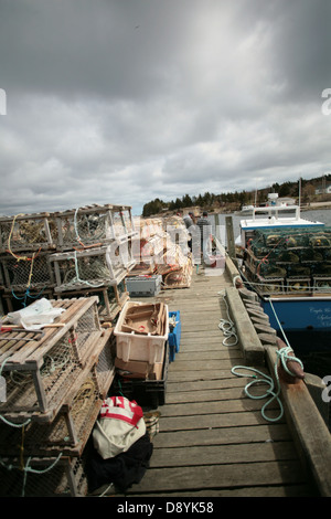 Casiers à homard s'asseoir sur un petit quai qui héberge quelques bateaux de pêche du homard dans la région le long du Cap Breton, Nouvelle-Écosse Cabot Trail. Banque D'Images