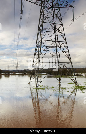 Pylônes d'électricité se tenant dans la campagne inondée dans la vallée de l'exe de la rivière, à Stoke Canon, près d'Exeter, Devon, Grande-Bretagne. Banque D'Images