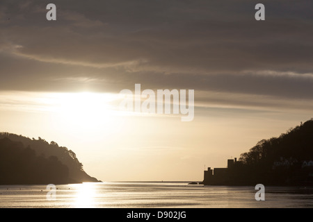 Lever du soleil sur l'hiver de l'estuaire de la rivière Dart avec Dartmouth Castle se découpant sur la droite. Banque D'Images
