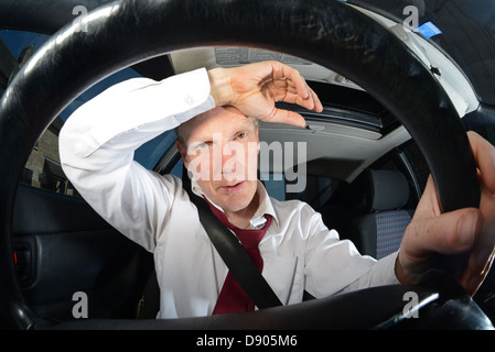 Fatigué businessman driving car Banque D'Images