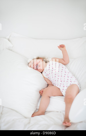Little girl lying on bed and laughing Banque D'Images