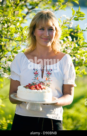 Femme avec un gâteau aux fraises, Fejan, archipel de Stockholm, Suède.