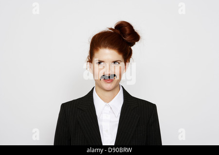 Une femme en costume portant une fausse moustache. Banque D'Images