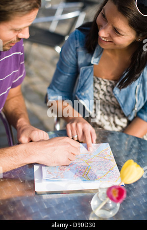 Couple sitting in cafe avec la carte Banque D'Images
