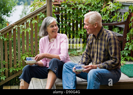 Senior couple sitting on steps, le café Banque D'Images