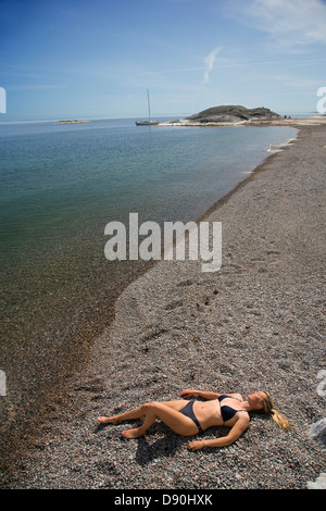 Woman lying on beach Banque D'Images