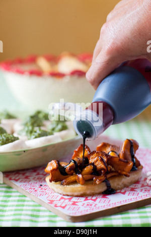 Close up de sirop à la main sur les chanterelles avec sandwich Banque D'Images