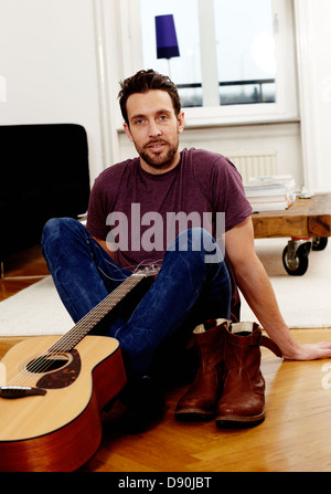 Homme assis avec guitare, portrait Banque D'Images