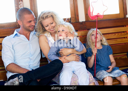 Les parents assis avec des enfants, smiling Banque D'Images