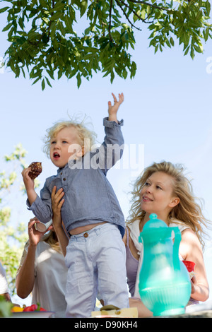 Family having picnic, boy standing with arms up Banque D'Images