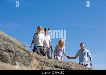 Deux couples Walking Together on rock Banque D'Images