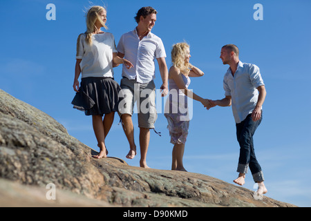 Deux couples Walking Together on rock Banque D'Images