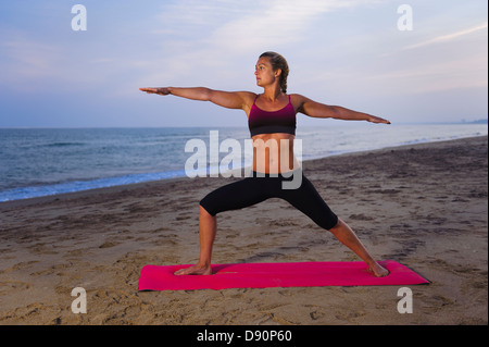 Les femmes faisant du yoga on beach Banque D'Images