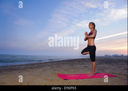 Les femmes faisant du yoga on beach Banque D'Images