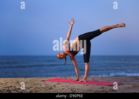 Les femmes faisant du yoga on beach Banque D'Images