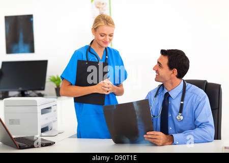 Friendly male medical doctor talking to female nurse in office Banque D'Images