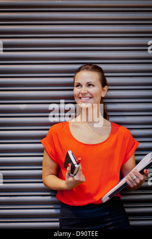 Portrait de jeune femme tenant son journal et documents Banque D'Images