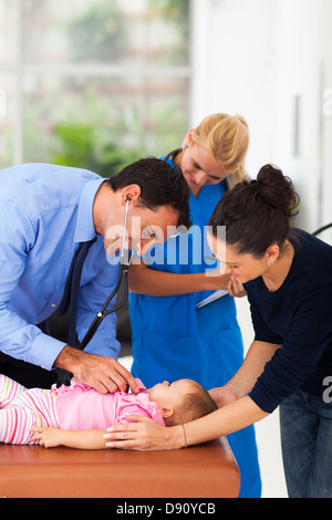 Prendre soin médecin examinant un bébé malade girl in office Banque D'Images