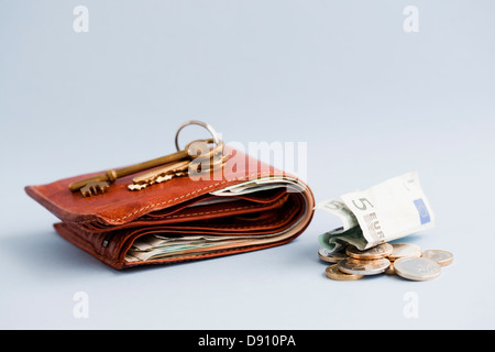 Porte-monnaie avec de l'argent et des clés Banque D'Images