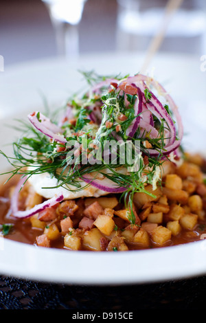 Hachage de poêlée de poisson en dés avec des oignons et des pommes de terre, close-up. Banque D'Images